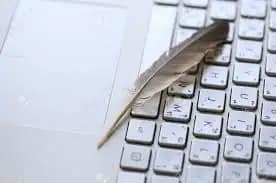 Plume d'oiseau posé sur clavier d'ordinateur inspirant Storytelling